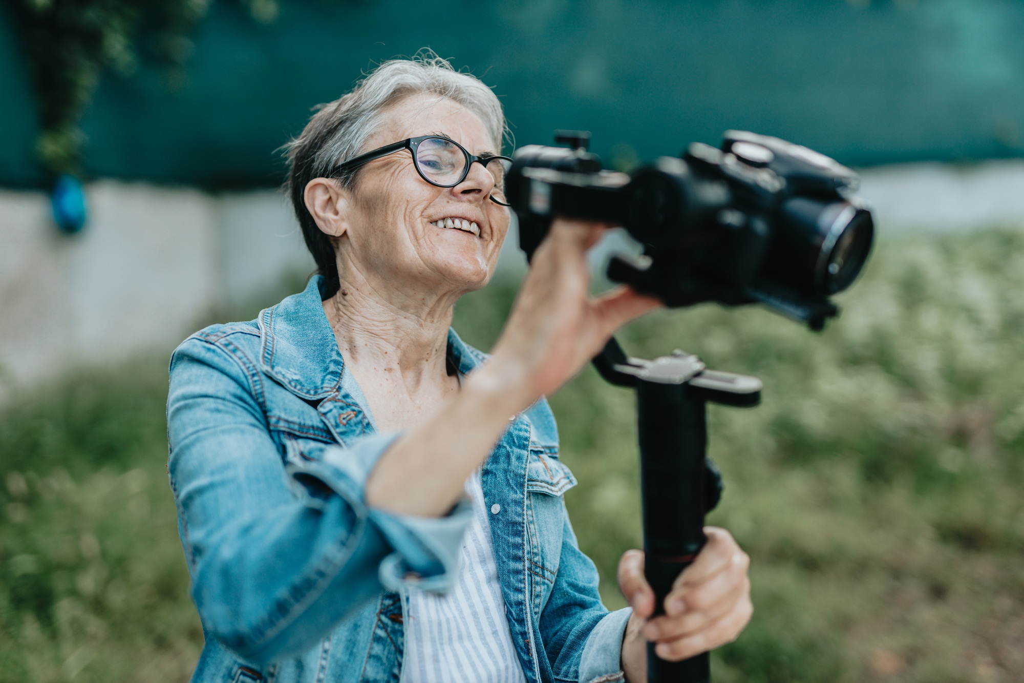 Concentrated senior woman arranging and preparing to record with her camera, photos and videos.