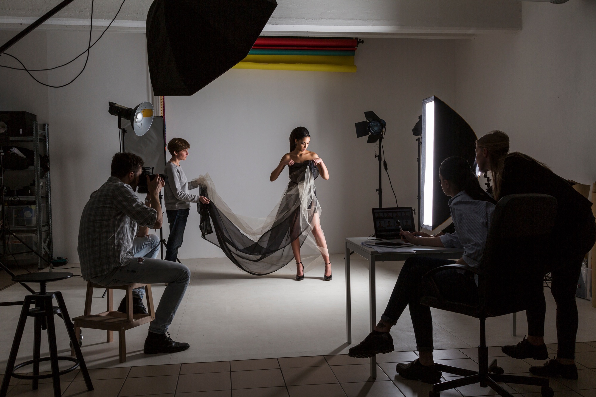 Photography team and model in low key photography studio shoot