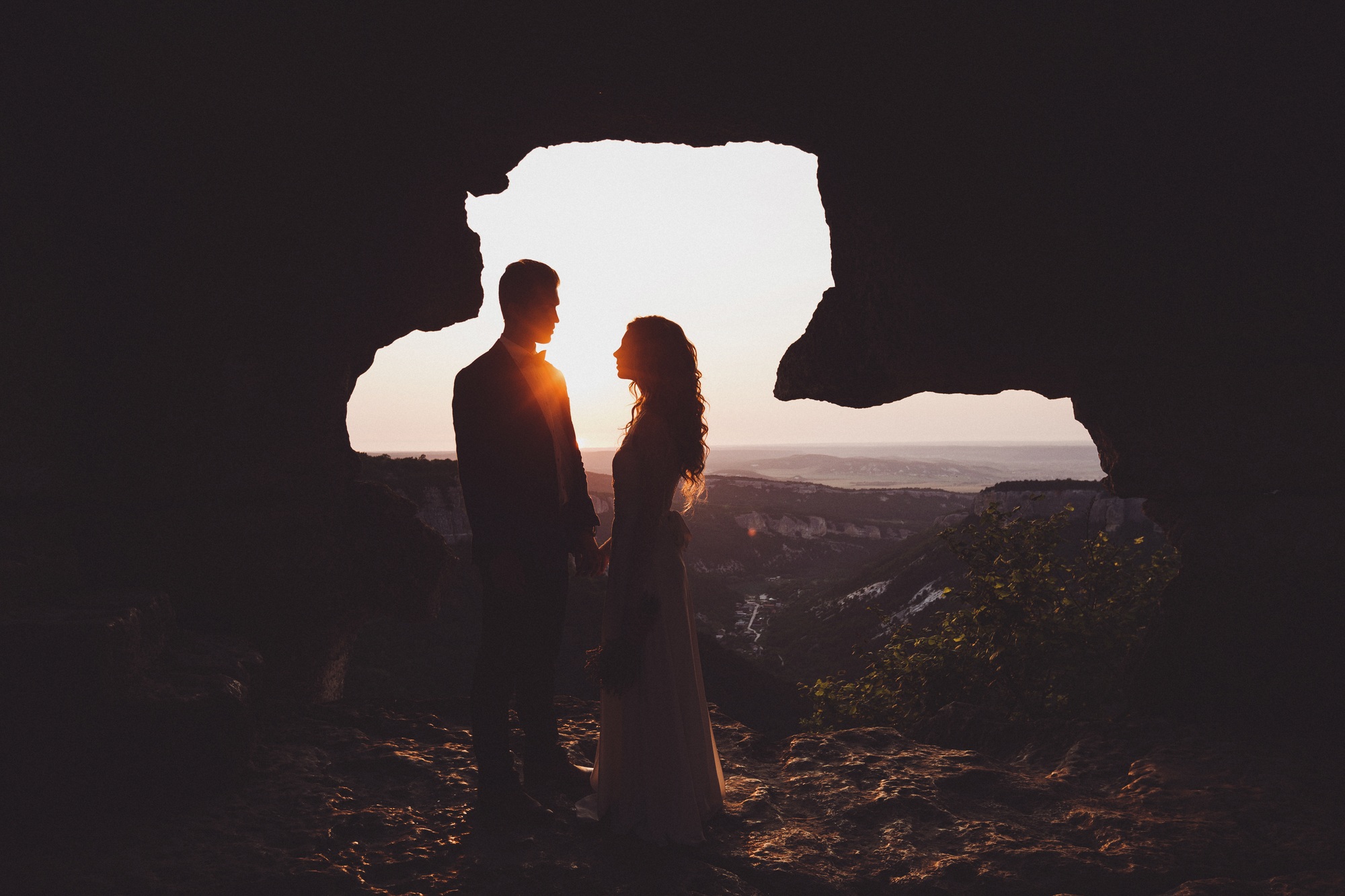Unusual wedding photography. Sunset in muntains with silhouettes newlyweds